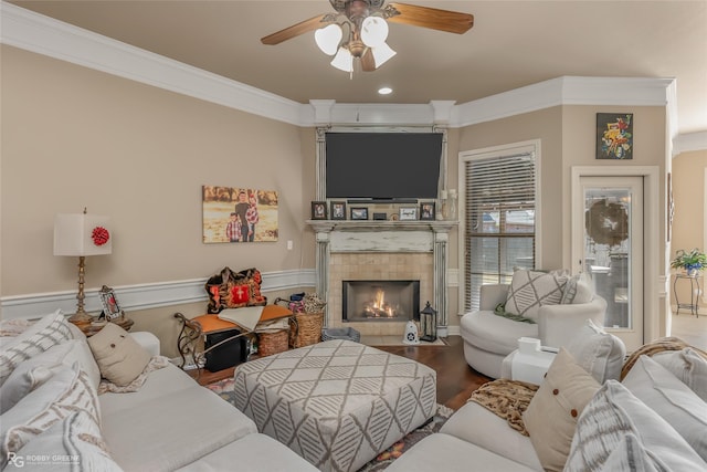 living room featuring a fireplace, ceiling fan, hardwood / wood-style flooring, and crown molding