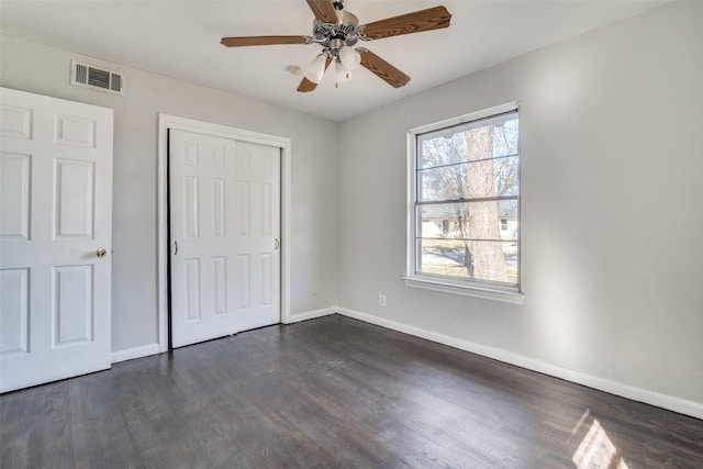 unfurnished bedroom with a closet, ceiling fan, and dark wood-type flooring