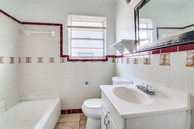 bathroom with tile walls, tile patterned flooring, a tub, and vanity