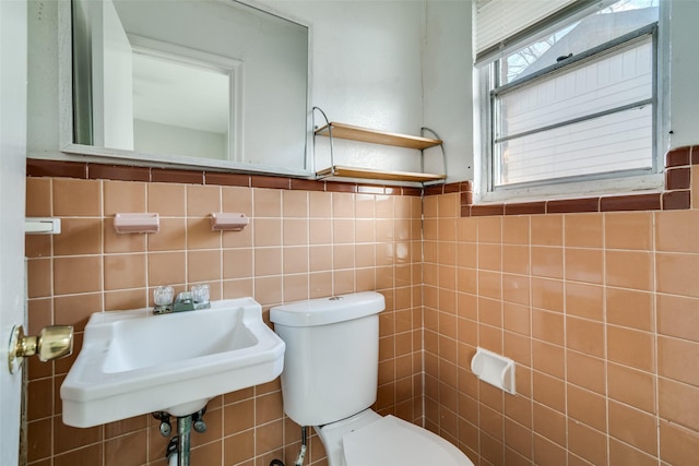 bathroom with tile walls, toilet, and sink