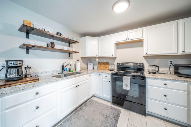 kitchen featuring black range with electric stovetop, light stone counters, sink, white cabinetry, and light tile patterned flooring