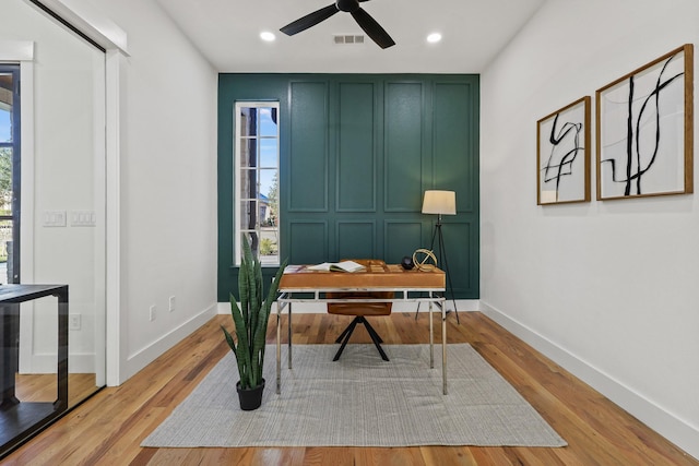 office space with light hardwood / wood-style floors, ceiling fan, and a wealth of natural light