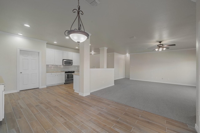 unfurnished living room featuring ornamental molding, ceiling fan, and light hardwood / wood-style flooring