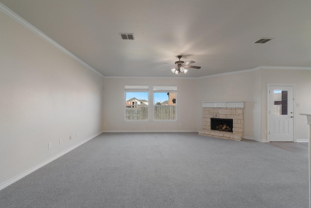 unfurnished living room featuring light carpet, ceiling fan, crown molding, and a stone fireplace