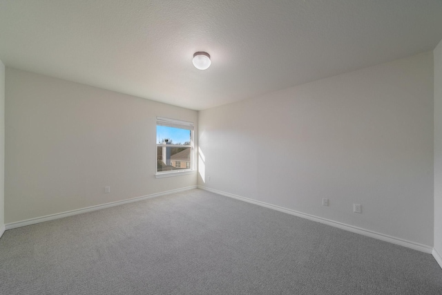 carpeted empty room with a textured ceiling