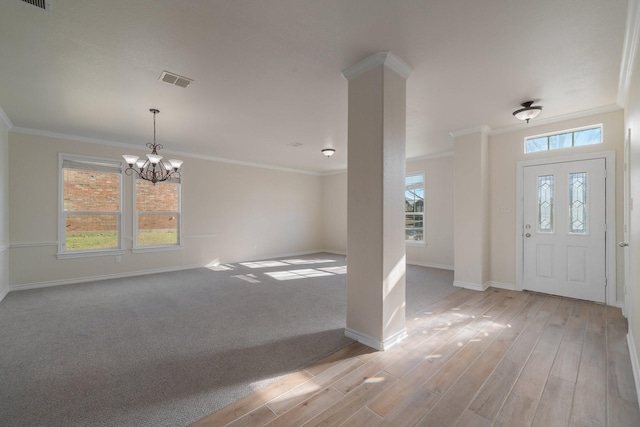 entryway featuring an inviting chandelier, light wood-type flooring, and crown molding