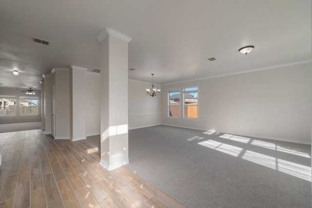 carpeted empty room with ornamental molding and ceiling fan with notable chandelier