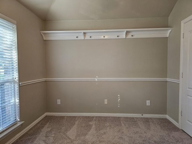 carpeted spare room with vaulted ceiling