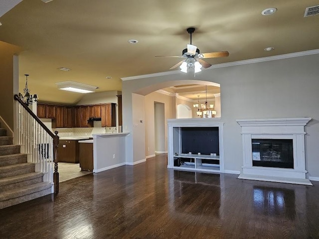 unfurnished living room featuring ornamental molding, dark hardwood / wood-style flooring, and ceiling fan with notable chandelier