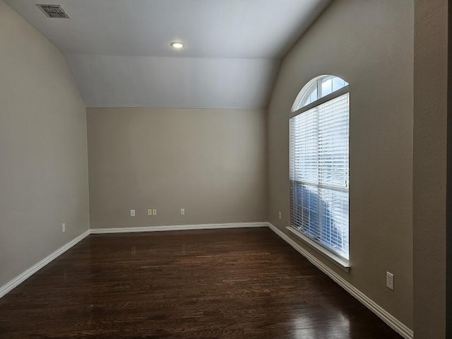 empty room featuring lofted ceiling and dark wood-type flooring