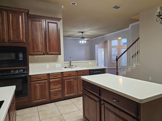 kitchen with sink, ornamental molding, light tile patterned floors, tasteful backsplash, and black appliances