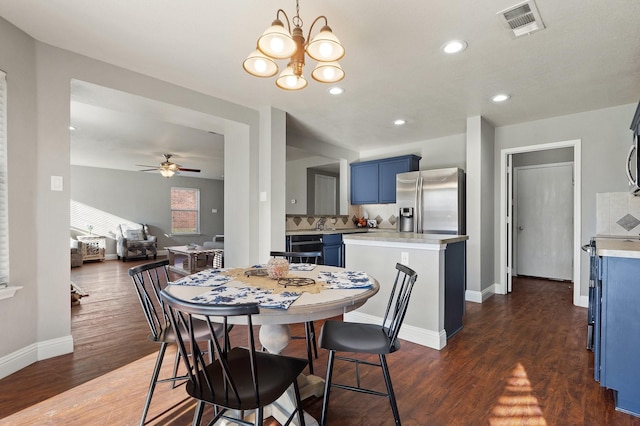 dining room featuring dark hardwood / wood-style floors and ceiling fan with notable chandelier