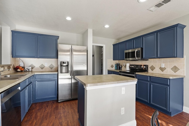 kitchen featuring appliances with stainless steel finishes, blue cabinetry, dark wood-type flooring, a kitchen island, and sink