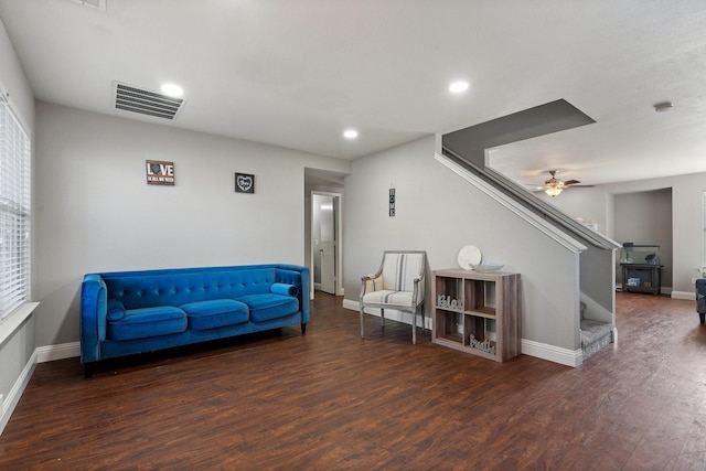 living area featuring ceiling fan and dark hardwood / wood-style floors