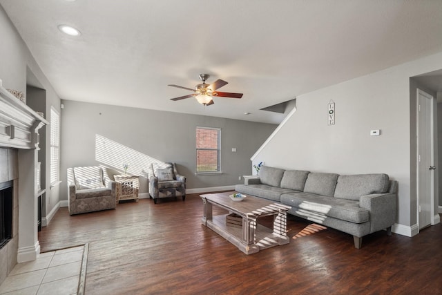 living room with a tile fireplace, ceiling fan, and hardwood / wood-style floors