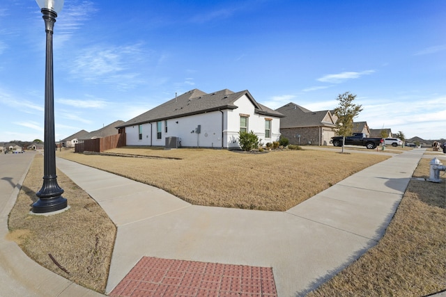 view of home's exterior with a lawn and central AC unit