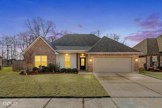 view of front of house with a garage and a lawn