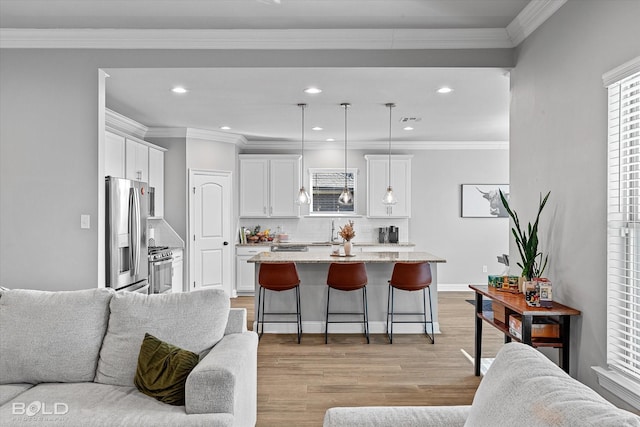 kitchen featuring stainless steel appliances, a kitchen island, white cabinets, and pendant lighting