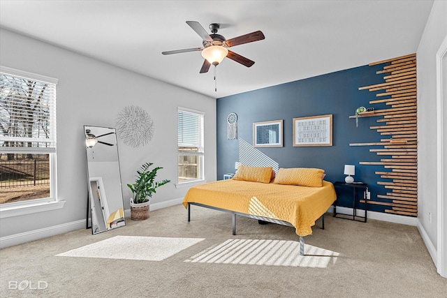 bedroom with multiple windows, ceiling fan, and light colored carpet