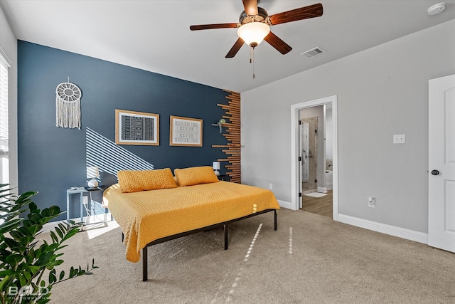 bedroom with ensuite bathroom, carpet flooring, and ceiling fan