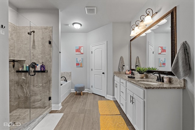 bathroom with shower with separate bathtub, vanity, and hardwood / wood-style flooring