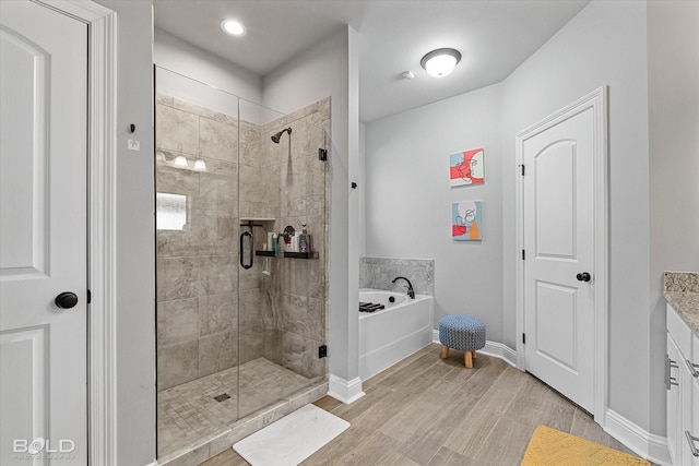 bathroom featuring hardwood / wood-style floors, separate shower and tub, and vanity