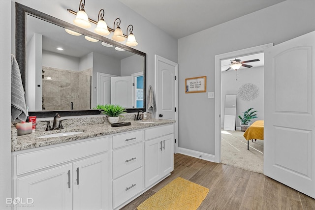 bathroom with vanity, walk in shower, and ceiling fan