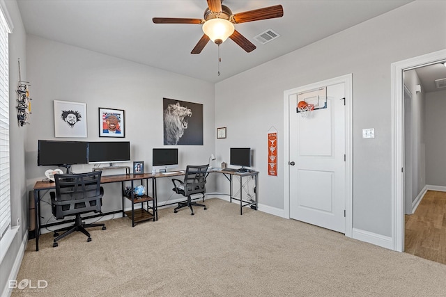 carpeted office space with ceiling fan