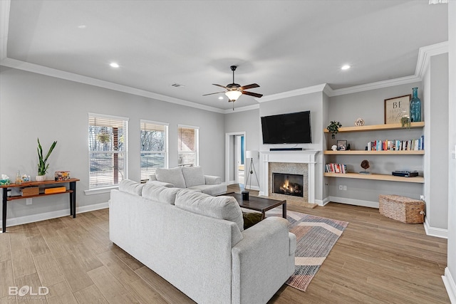 living room with light hardwood / wood-style floors, ceiling fan, and crown molding