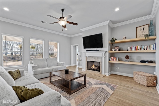 living room with ceiling fan, light hardwood / wood-style floors, and crown molding