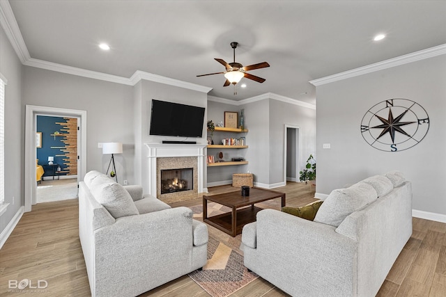 living room featuring ceiling fan, ornamental molding, and light hardwood / wood-style flooring