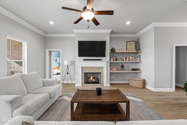 living room with light wood-type flooring, ceiling fan, and ornamental molding