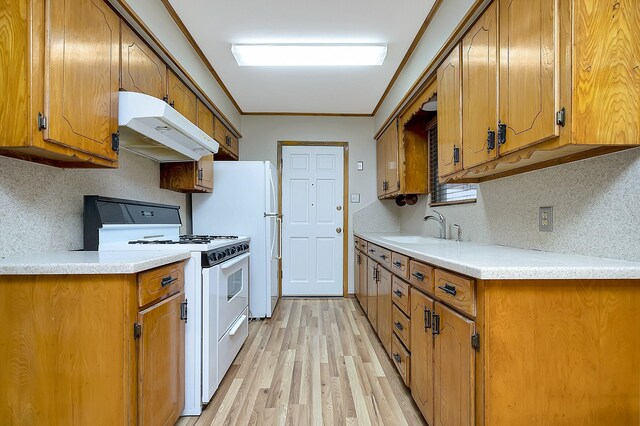 kitchen with white appliances, light wood-type flooring, tasteful backsplash, and sink