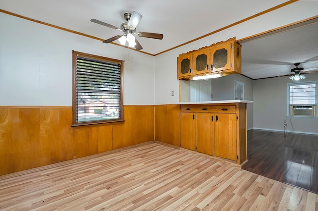 kitchen featuring light wood-type flooring, ceiling fan, kitchen peninsula, cooling unit, and crown molding