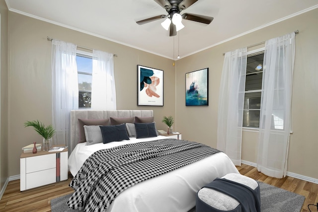 bedroom with light wood-type flooring, ceiling fan, and crown molding