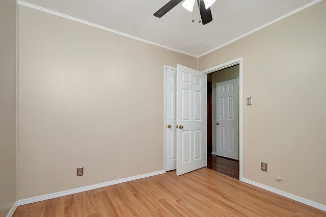 unfurnished room featuring ceiling fan, light wood-type flooring, and crown molding