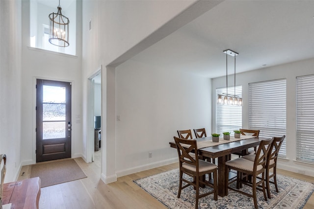 dining space featuring light hardwood / wood-style flooring and a chandelier