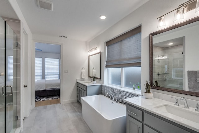 bathroom with vanity, a wealth of natural light, and separate shower and tub