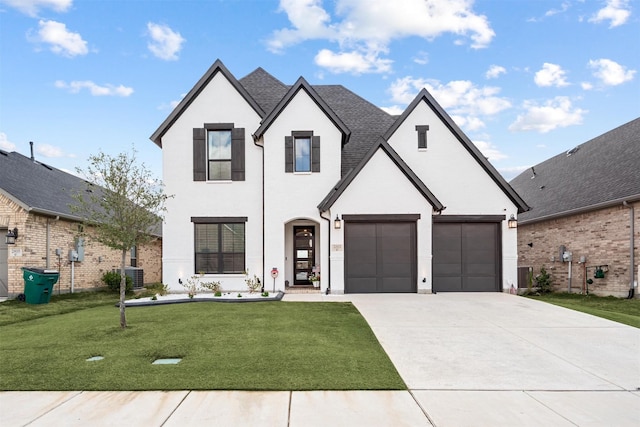 view of front of house featuring central AC unit, a front yard, and a garage