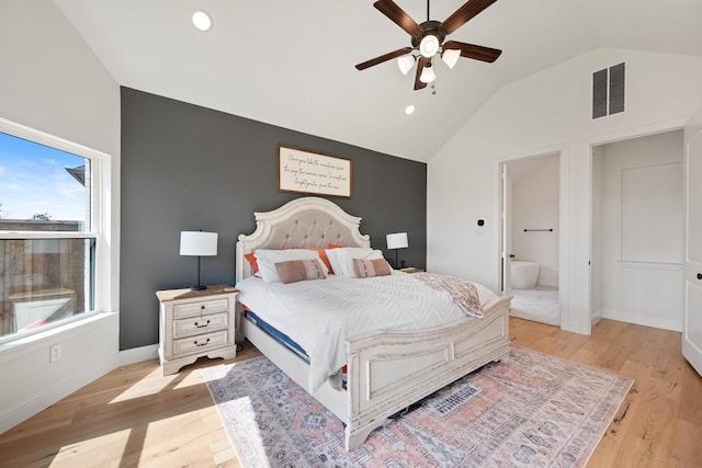 bedroom featuring ensuite bathroom, ceiling fan, vaulted ceiling, and light wood-type flooring