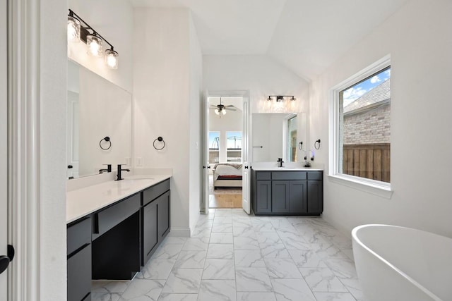 bathroom with vaulted ceiling, a bathtub, plenty of natural light, ceiling fan, and vanity