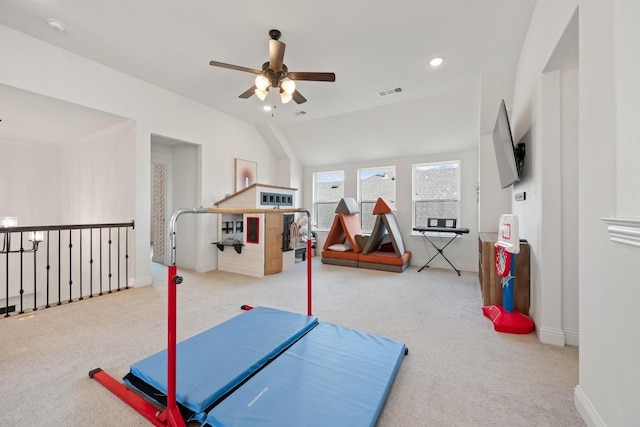 exercise area featuring light colored carpet, ceiling fan, and vaulted ceiling