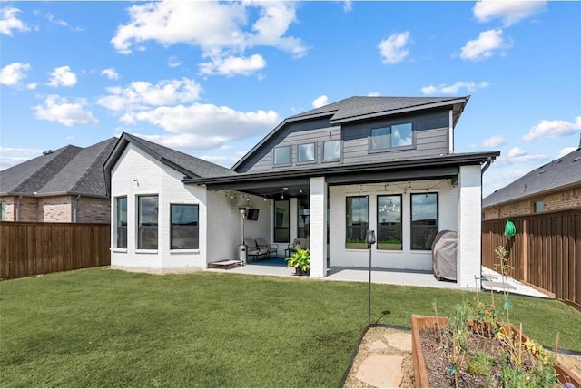 rear view of house featuring a yard and a patio