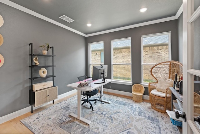 office with light wood-type flooring, a healthy amount of sunlight, and crown molding