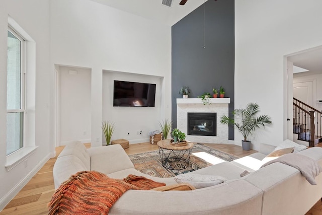 living room featuring high vaulted ceiling, ceiling fan, and light hardwood / wood-style floors