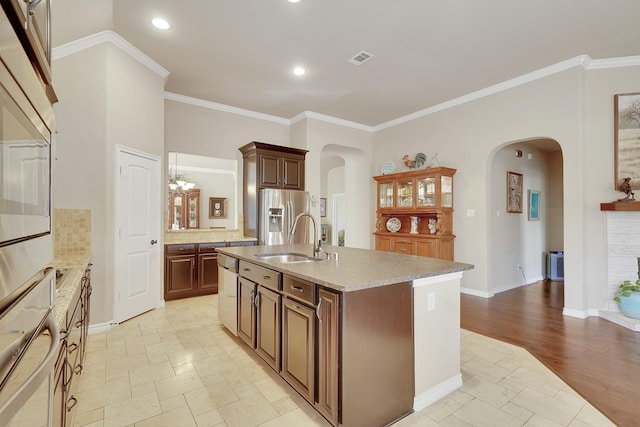 kitchen featuring appliances with stainless steel finishes, arched walkways, visible vents, and a sink