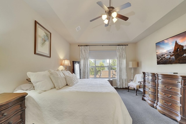 bedroom with lofted ceiling, visible vents, a ceiling fan, a tray ceiling, and carpet