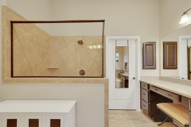 full bath with walk in shower, wood finished floors, and vanity