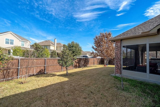 view of yard with a fenced backyard and a sunroom