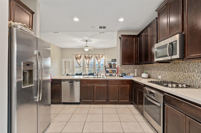 kitchen with tasteful backsplash, light countertops, visible vents, appliances with stainless steel finishes, and a sink